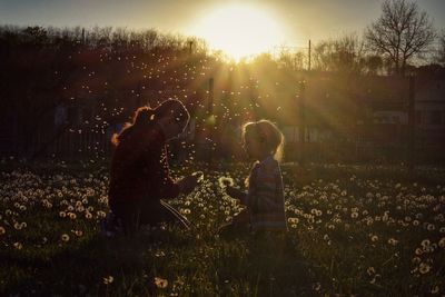 People on field against sky during sunset