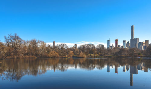 Reflection of trees in lake against blue sky