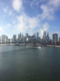 Sea by buildings against sky in city