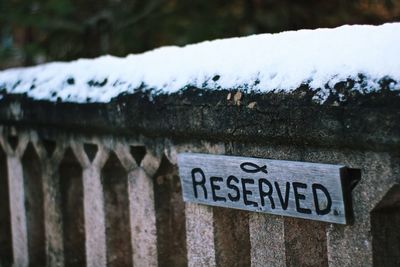 Close-up of information sign on snow