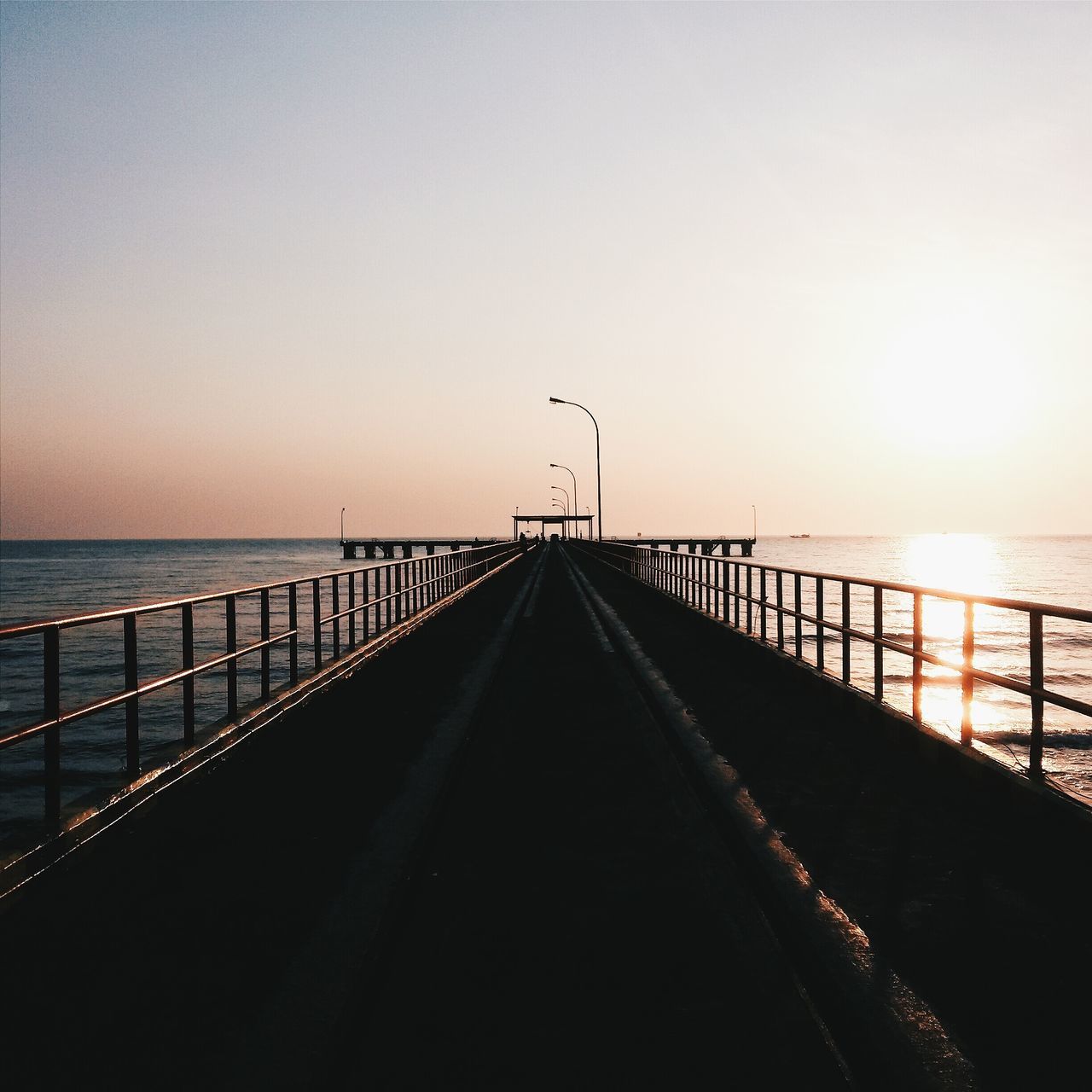 sea, horizon over water, the way forward, water, sunset, clear sky, diminishing perspective, tranquil scene, tranquility, railing, scenics, copy space, pier, beach, vanishing point, beauty in nature, nature, sky, idyllic, street light