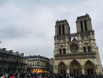 People at cathedral against sky