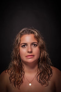 Portrait of a beautiful young woman over black background