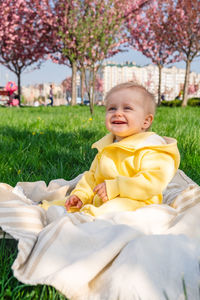 Portrait of cute baby boy lying on grass