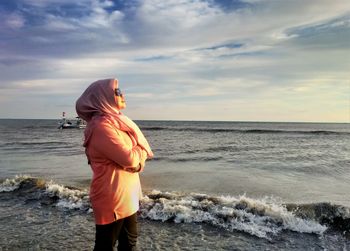 Rear view of woman standing on beach