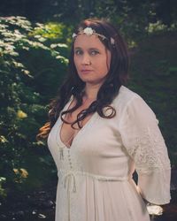 Young woman standing against tree