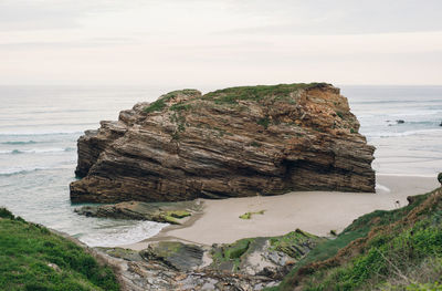 Scenic view of rocks on beach against sky