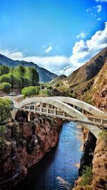 Arch bridge over river against sky