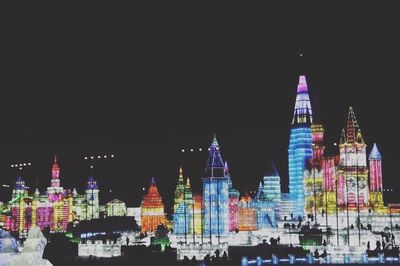 Illuminated buildings against sky at night