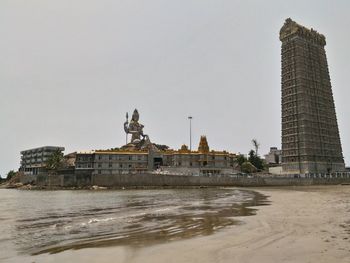 Temple building with statue of lord shiva by sea