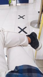 Low section of man standing on tiled floor