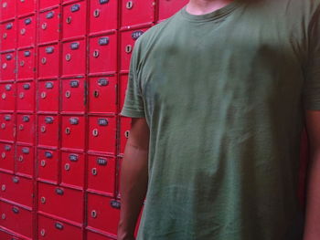 Midsection of man standing on red wall