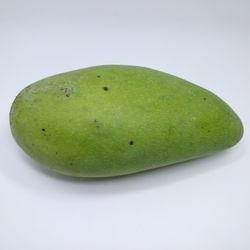 High angle view of green fruit against white background