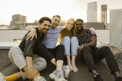 Portrait of friends sitting on sofa at home