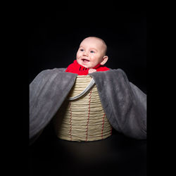 Portrait of cute baby against black background