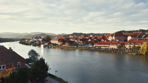 High angle view of river amidst houses against sky