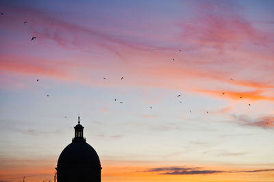 Low angle view of built structure against sky at sunset