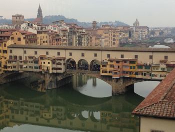 Ponte vecchio reflecting on arno river, florence