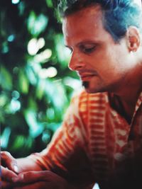 Side view of young man sitting outdoors