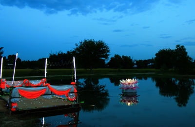 Boats moored in lake against blue sky