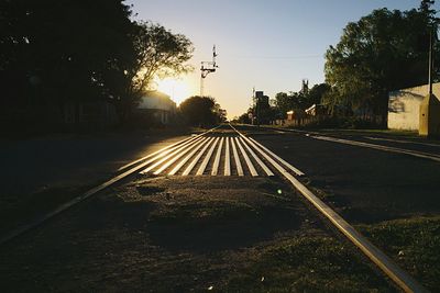 Road in city against sky during sunset