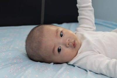 Portrait of cute baby lying on bed