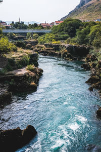 River flowing through rocks against sky