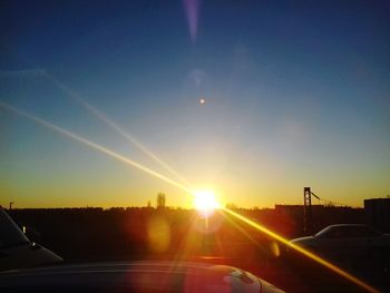 Cars on road against sky during sunset