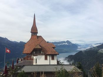 Temple against building and mountains against sky