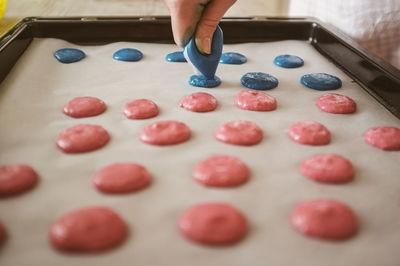 Cropped image of hand making cookies in baking sheet