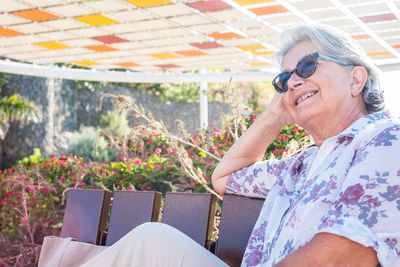 Smiling woman sitting on bench at park