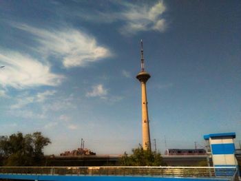 Communications tower against cloudy sky