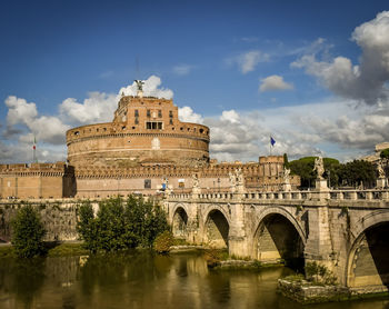 Arch bridge over river against buildings