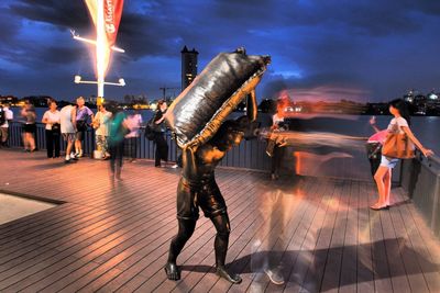 Full length of man standing on illuminated street at night