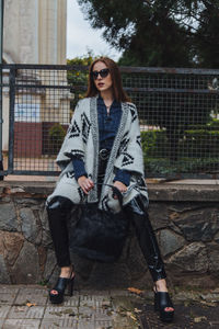 Portrait of young woman wearing sunglasses standing outdoors