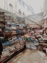 Stack of books on staircase by buildings in city