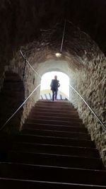 Rear view of woman walking up stairs