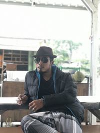 Young man wearing sunglasses sitting on seat