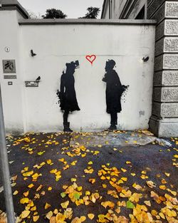 Full length of people standing on footpath during autumn