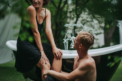 People sitting in swimming pool against trees