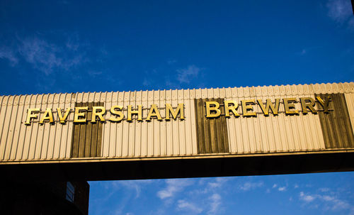 Low angle view of information sign against sky