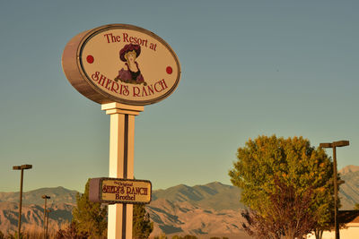 Low angle view of road sign against clear sky