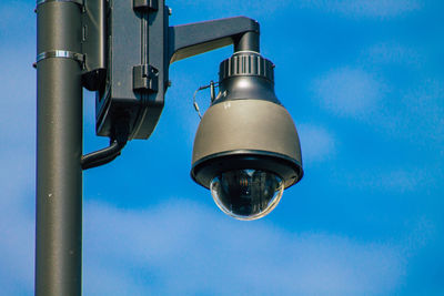 Low angle view of electric lamp against blue sky