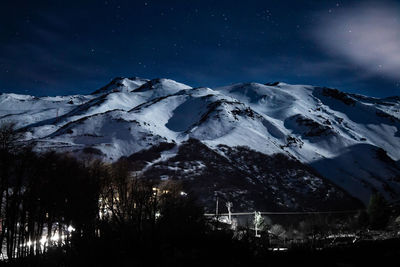 Scenic view of snowcapped mountains against sky at night