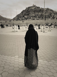 Rear view of people on sand against sky