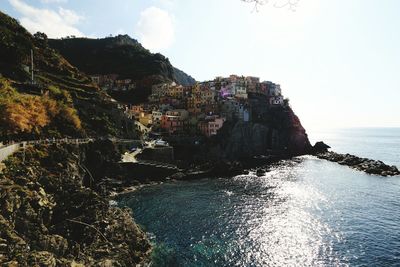 Scenic view of sea by cliff against sky