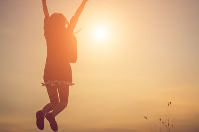 Silhouette woman standing against sky during sunset