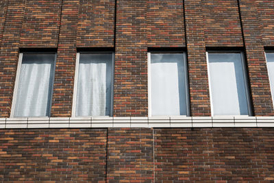 Low angle view of window on brick wall of building