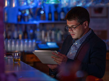 Businessman using digital tablet at bar