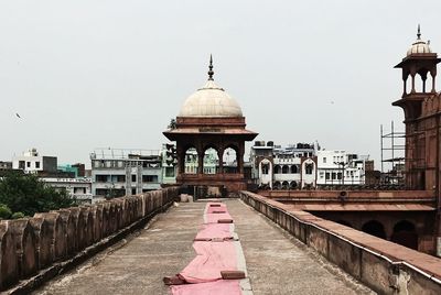 Rear view of women amidst buildings in city against sky